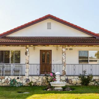 A charming residential house with a garden and front porch.