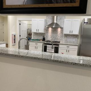 A modern kitchen with white cabinets and stainless steel appliances.
