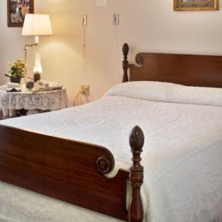 A cozy bedroom with a wooden bed and elegant decor.