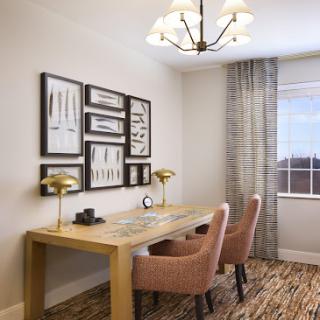 A modern home office setup featuring a wooden desk, two stylish chairs, and decorative wall art.