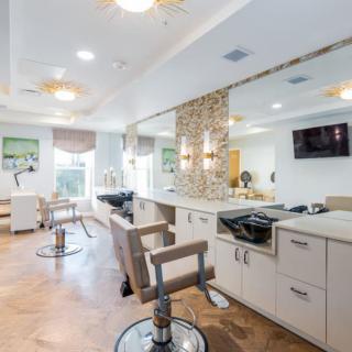 A modern and spacious salon interior with multiple chairs and mirrors.