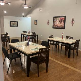An inviting dining area with neatly arranged tables and chairs, adorned with decorative wall art.