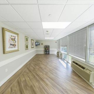 A well-lit hallway with wooden floors and artwork on the walls.