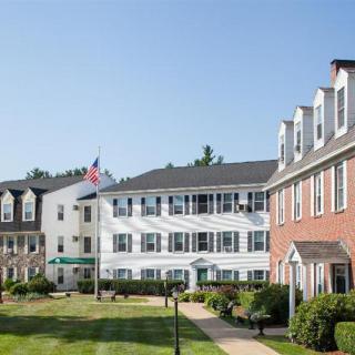 A view of residential buildings with well-maintained lawns and an American flag displayed.