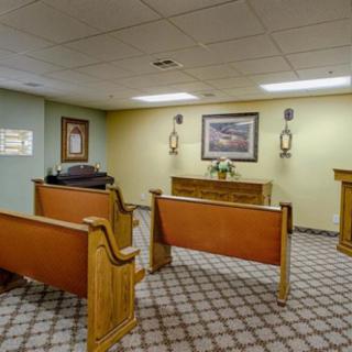 A quiet chapel interior with wooden pews and decorative elements.