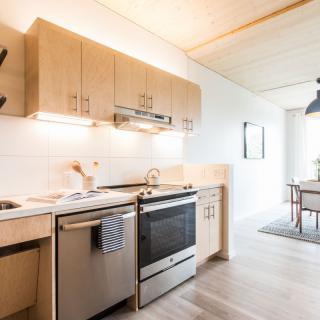 A modern kitchen with wooden cabinets and stainless steel appliances.