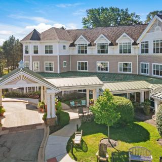 A large residential building with a landscaped entrance and covered walkway.