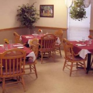 A cozy dining room with tables and chairs set for guests.