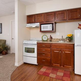 Cozy apartment kitchen with brown cabinets and modern appliances.