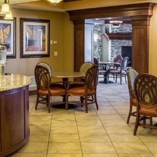 A cozy dining area with wooden chairs and a table on a tiled floor.