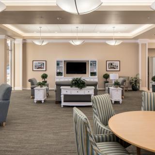 A spacious lounge area with comfortable seating and a television.