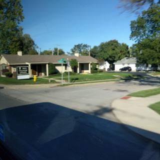 A quiet suburban neighborhood featuring residential homes and clear blue skies.