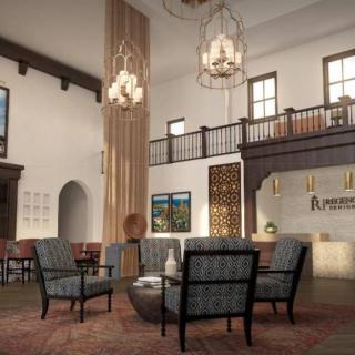 A stylish hotel lobby featuring elegant chandeliers, comfortable seating, and a welcoming reception desk.