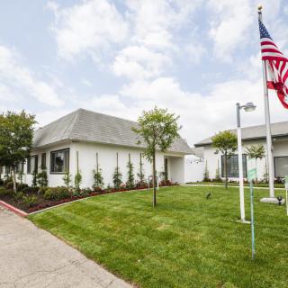 A suburban house with a neatly maintained lawn and an American flag displayed outside.