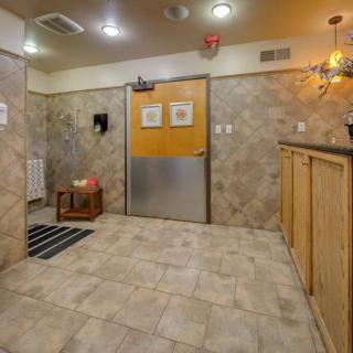 A cozy waiting area with tiled walls and floors, featuring a wooden counter and ceiling lights.