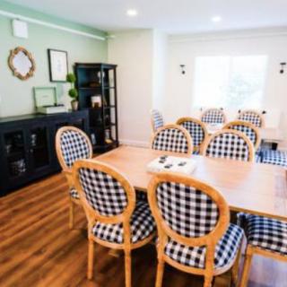 A modern dining room with checkered chairs and a large wooden table.