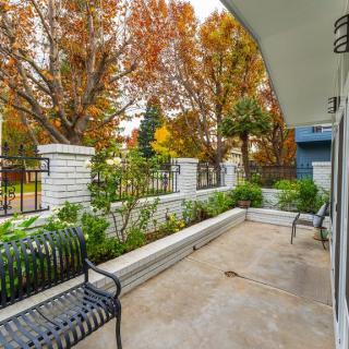 A tranquil patio area surrounded by autumn trees, featuring benches and a garden.