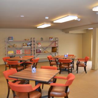 A quiet reading area with tables and chairs, surrounded by bookshelves.