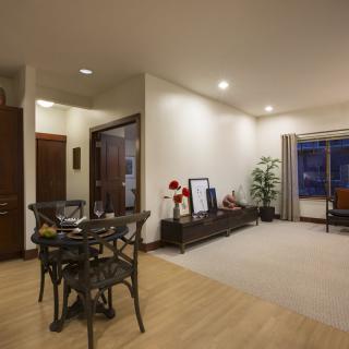 A modern living room with a dining area, featuring wooden flooring and contemporary furniture.