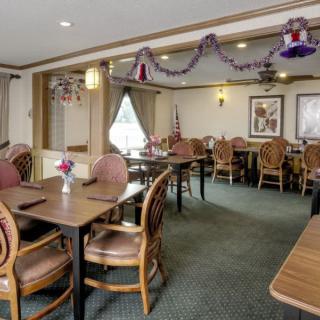 A cozy restaurant dining area with tables, chairs, and ceiling decorations.