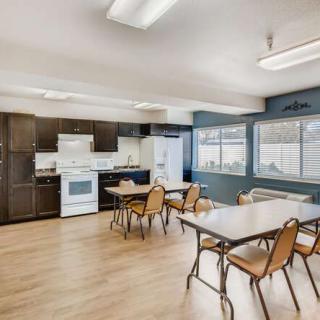 A spacious kitchen and dining area with tables, chairs, and modern appliances.