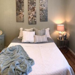 Cozy bedroom with a neatly made bed and soft lighting.