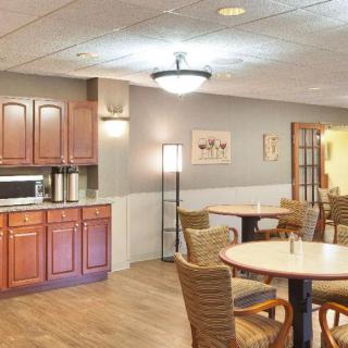 A cozy dining area with wooden furniture and a small kitchenette.
