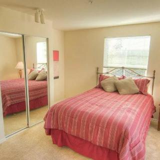 A cozy bedroom with a neatly made bed and mirrored closet doors.