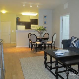 A modern apartment with an open-plan living room, dining area, and kitchen.
