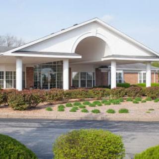 A large building with a prominent entrance featuring columns and well-maintained landscaping.
