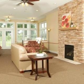 A cozy and inviting living room featuring a comfortable sofa, decorative fireplace, and ample natural light.