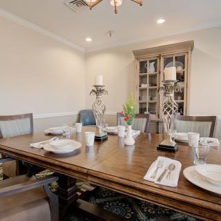 A dining room with a table set for a meal, featuring elegant decor and candles.