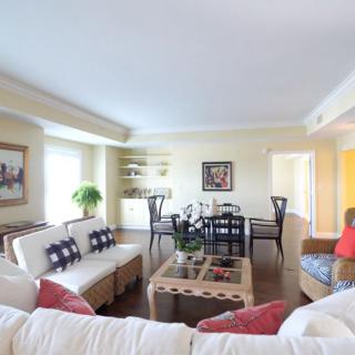 A bright and cozy living room with a dining area, featuring comfortable sofas and stylish decor.