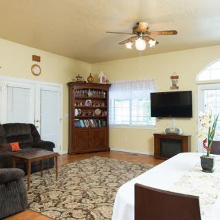A cozy living room with a sofa, television, and bookshelf, complemented by a dining area.