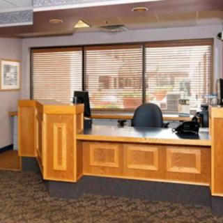 The image shows a reception area with a desk and a window behind it.