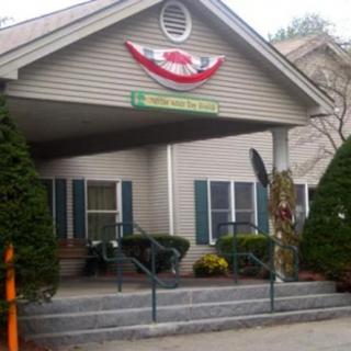 A decorated building entrance with stairs and greenery on either side.