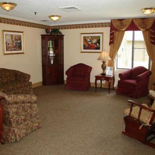A cozy living room with armchairs, a sofa, and elegant curtains.
