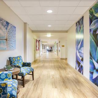 A well-decorated hallway with chairs and artwork on the walls.