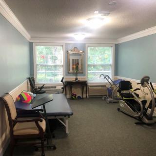 A physical therapy room equipped with various rehabilitation equipment and exercise machines.