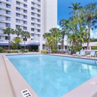 A serene outdoor pool surrounded by palm trees in a hotel setting.