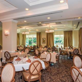 An elegant dining room with neatly arranged tables and chairs, ready for guests.