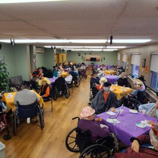 Residents of a nursing home gather in the dining area for a communal meal.