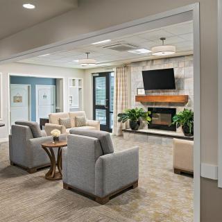 A modern living room with comfortable seating, a fireplace, and a wall-mounted television.
