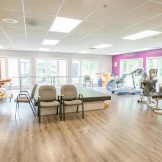A spacious and well-lit physical therapy facility designed for rehabilitation and exercise.