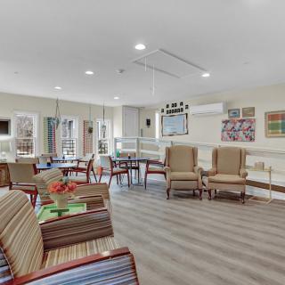 A bright and comfortable living room with multiple seating options, modern decor, and large windows.