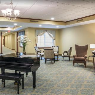 A sophisticated lobby featuring a grand piano and elegant seating arrangements.