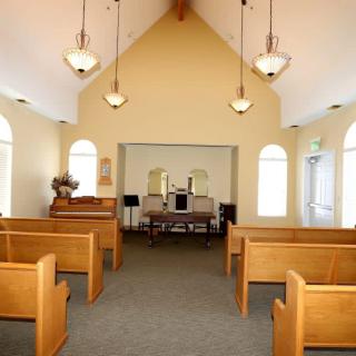 Interior view of a small chapel with wooden pews and altar.