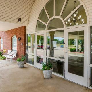 Entrance of a building with glass doors and potted plants.