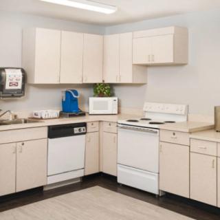 A modern kitchen featuring light-colored cabinets, a stove, microwave, dishwasher, and ample countertop space.