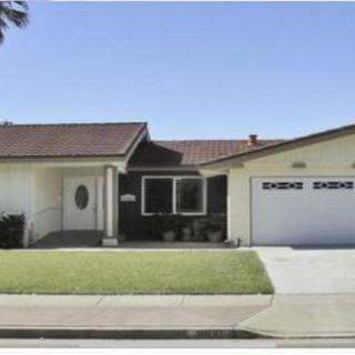A suburban single-story house with a garage and a well-maintained lawn.
